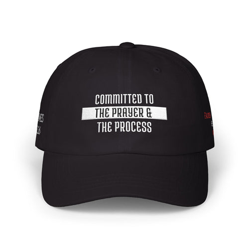 Black cap with 'Committed To The Prayer & The Process' text on a white background